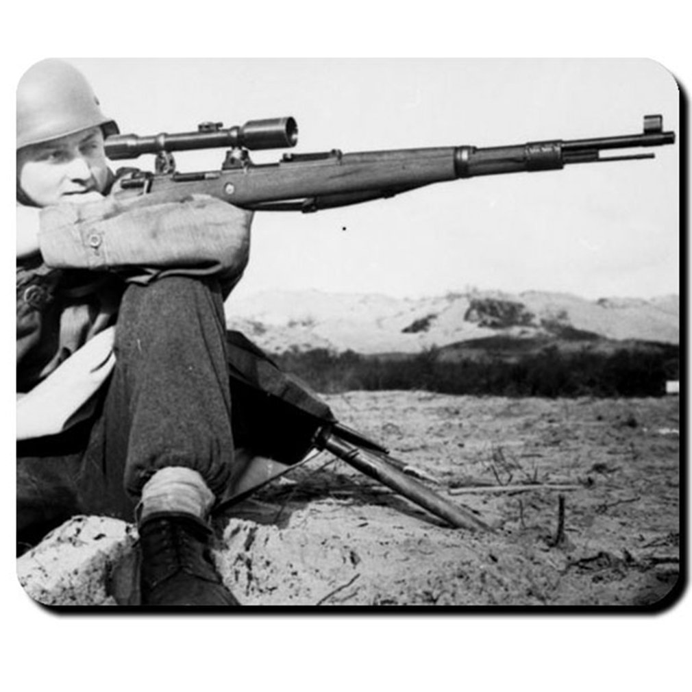 Black and white photo of a sniper looking through the sight of a gun